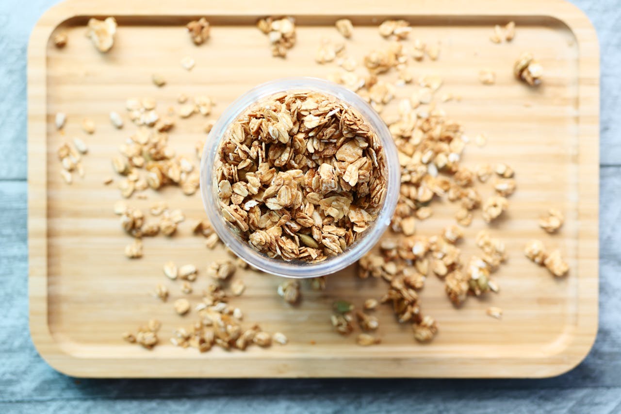 Crunchy granola in a jar on a wooden board, perfect for healthy breakfast ideas.